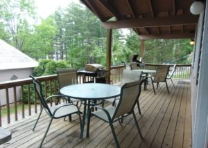 Forest Townhouse #109 covered porch with tables, chairs and gas grills
