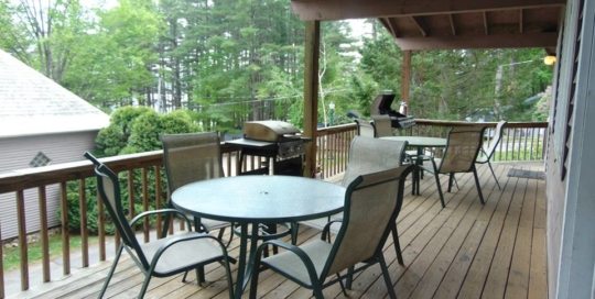 Forest Townhouse #109 covered porch with tables, chairs and gas grills