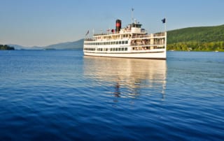 A Lake George Cruise soars on the blue waters.